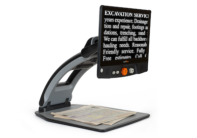 Reveal 16 by Humanware, with a newspaper under the camera, and showing on the 16" display.